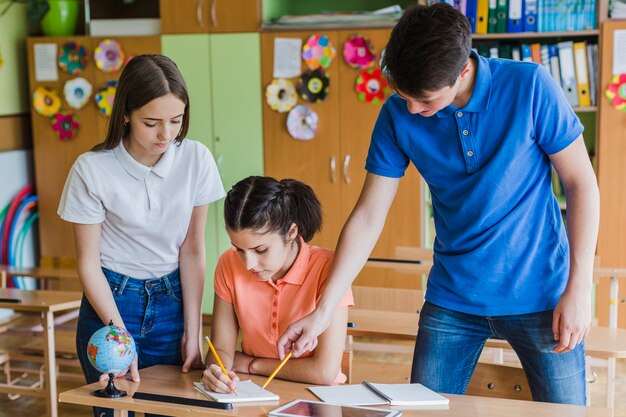 Group of students collaborating and writing notes together in a classroom setting