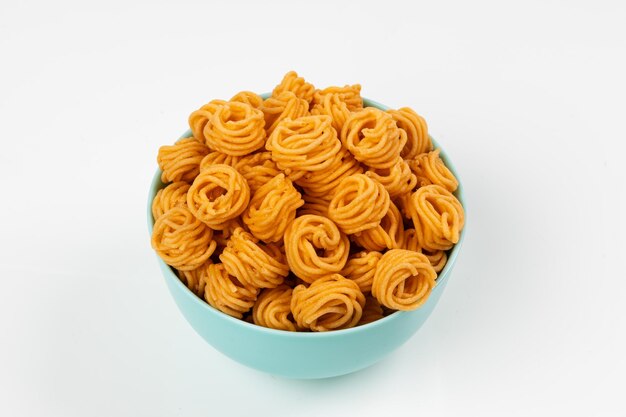 Spicy small spiral murukku snack isolated on a clean white background.